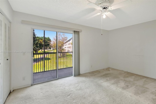 spare room featuring carpet flooring, a textured ceiling, and ceiling fan