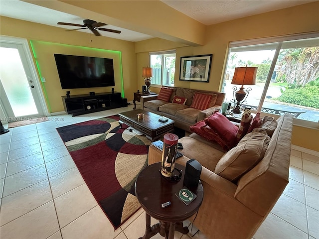 living room with baseboards, a ceiling fan, and light tile patterned flooring