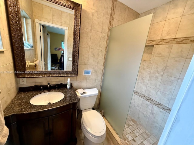 full bathroom featuring vanity, toilet, tile walls, a stall shower, and backsplash