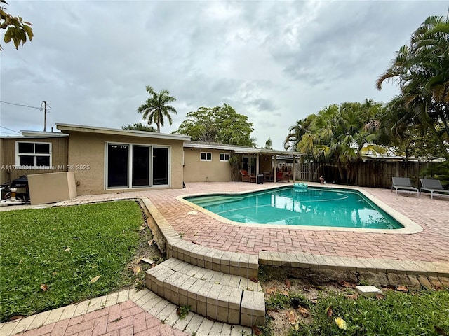 view of pool with a fenced in pool, a patio area, a yard, and fence