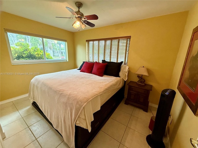 bedroom featuring baseboards, a ceiling fan, and light tile patterned flooring
