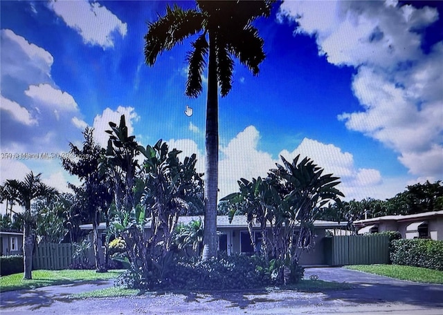 obstructed view of property with fence and driveway