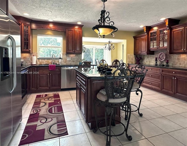 kitchen with stainless steel appliances, tasteful backsplash, a textured ceiling, and dark countertops