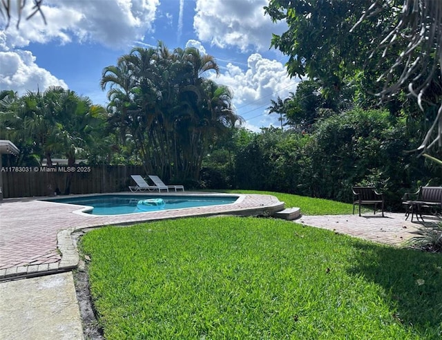 view of pool featuring a patio area, fence, a fenced in pool, and a yard