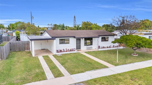 bungalow featuring a carport, a front lawn, fence, and driveway