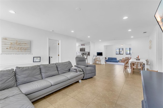 living area with recessed lighting, visible vents, and light tile patterned floors