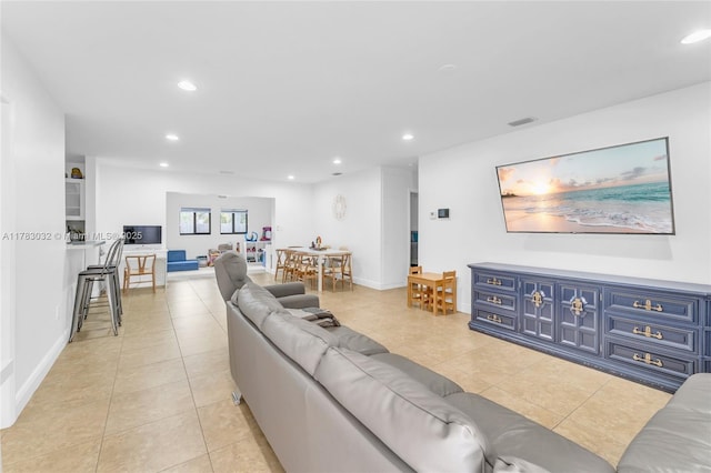 living area with light tile patterned floors, baseboards, recessed lighting, and visible vents