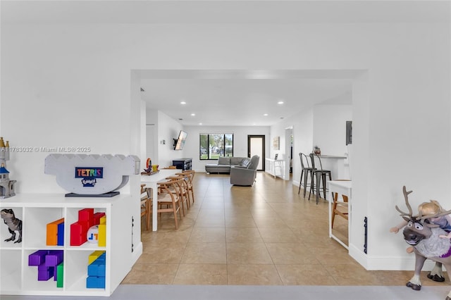 living area with baseboards, tile patterned flooring, and recessed lighting