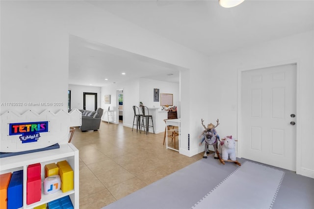 foyer entrance with recessed lighting, tile patterned floors, and baseboards