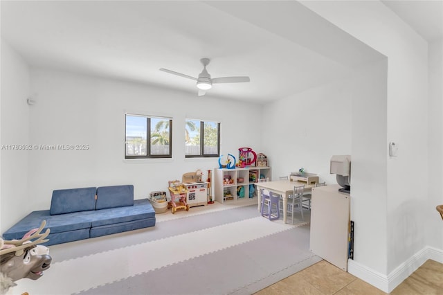 game room with tile patterned floors, baseboards, and ceiling fan