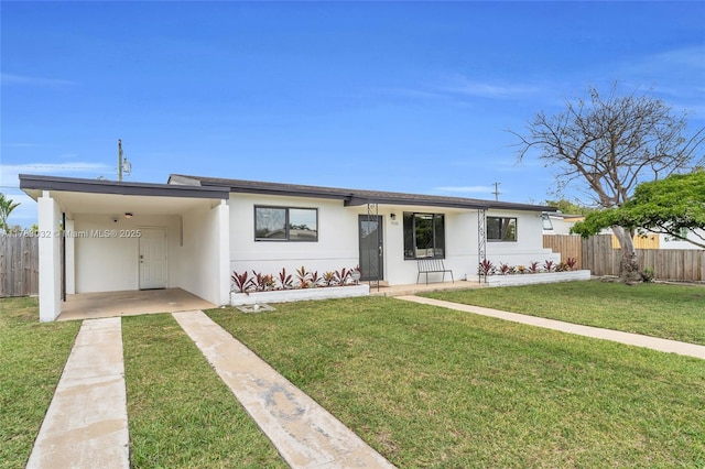 ranch-style house with driveway, a front yard, fence, and an attached carport