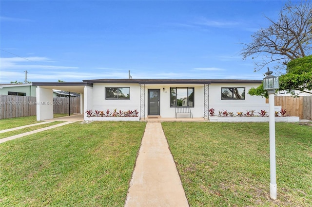 single story home with a front lawn, fence, and an attached carport