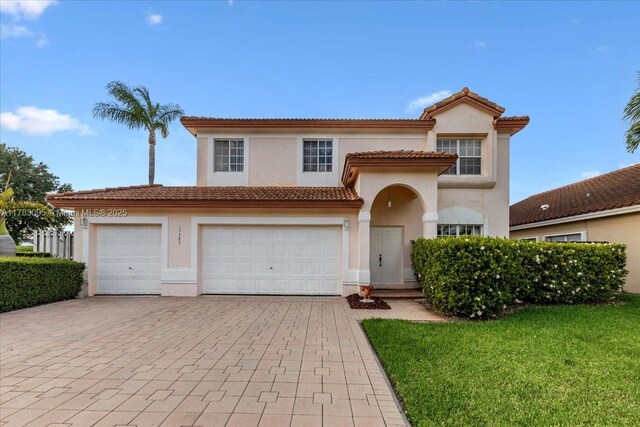 15489 SW 150th St, Miami, FL 33196 - mediterranean / spanish house with stucco siding, decorative driveway, a tiled roof, and a front lawn