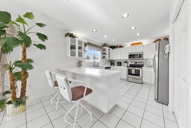 15489 SW 150th St, Miami, FL 33196 - kitchen with light tile patterned floors, tasteful backsplash, a peninsula, light countertops, and appliances with stainless steel finishes