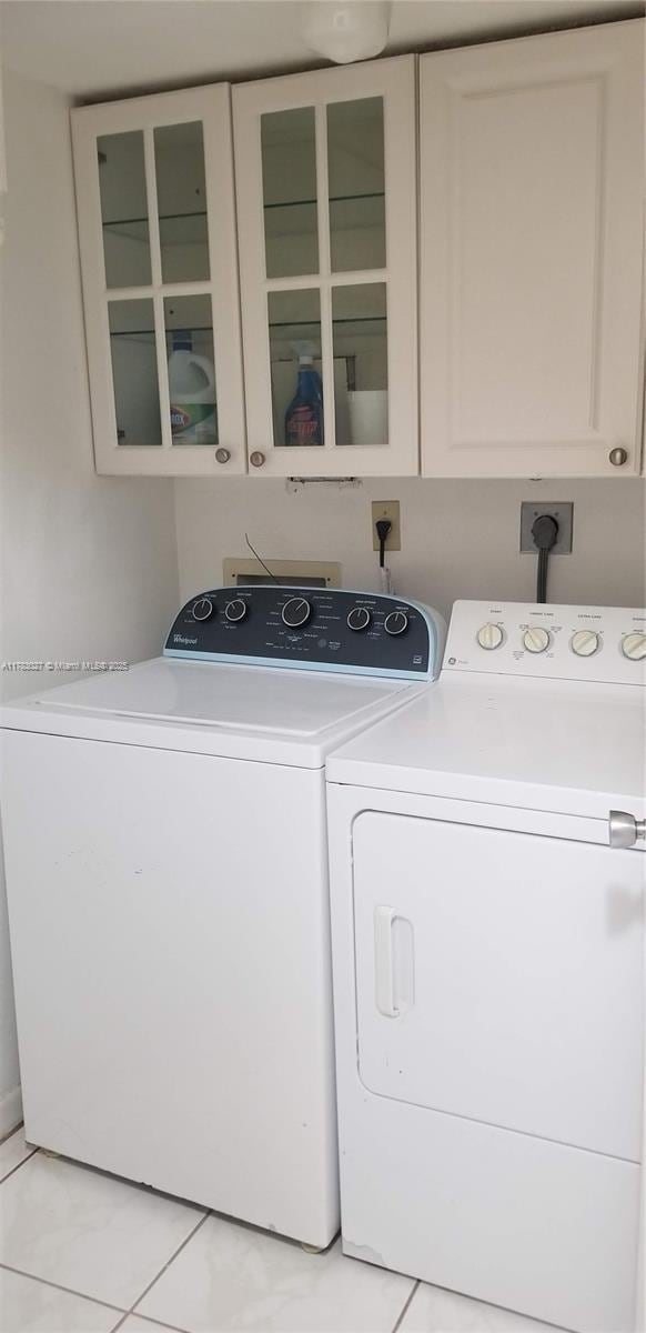 8850 SW 123rd Ct Unit H302, Miami, FL 33186 - clothes washing area with separate washer and dryer, light tile patterned flooring, and cabinet space