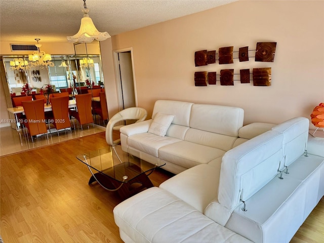 231 174th St Unit 2308, Sunny Isles Beach, FL 33160 - living room featuring a textured ceiling, wood finished floors, visible vents, and an inviting chandelier