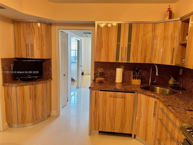 231 174th St Unit 2308, Sunny Isles Beach, FL 33160 - kitchen with dark stone counters, a sink, brown cabinetry, light tile patterned floors, and modern cabinets