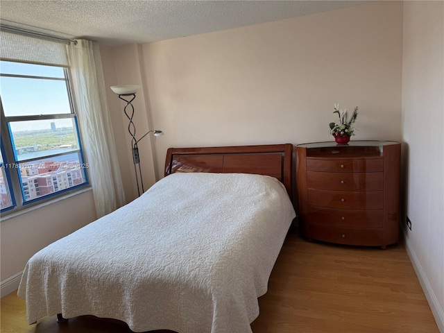 231 174th St Unit 2308, Sunny Isles Beach, FL 33160 - bedroom featuring baseboards, a textured ceiling, and light wood-type flooring