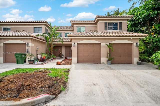 mediterranean / spanish-style home with a tile roof, driveway, and stucco siding