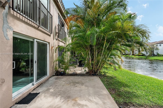 view of patio featuring a balcony and a water view