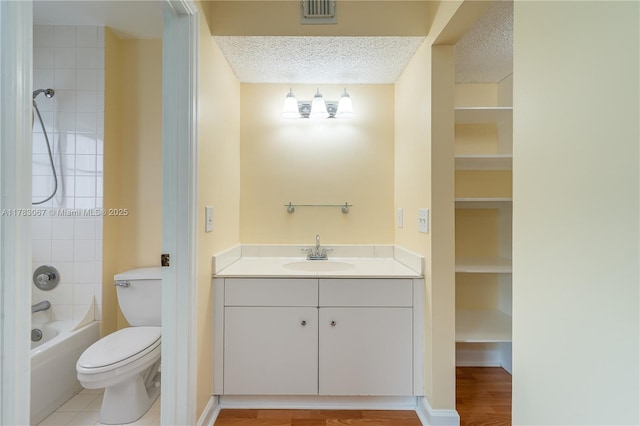 bathroom featuring visible vents, toilet, bathtub / shower combination, vanity, and wood finished floors