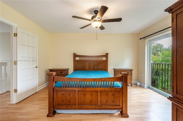bedroom featuring access to outside, baseboards, a textured ceiling, and light wood-style flooring