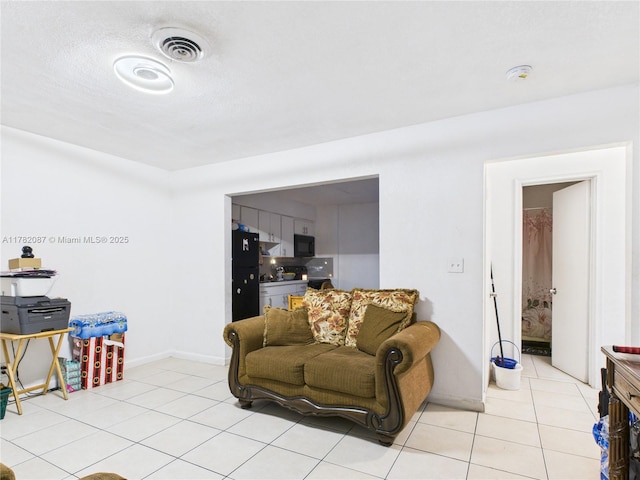 living area featuring visible vents, baseboards, and light tile patterned floors