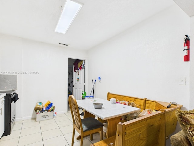 dining area featuring a skylight, visible vents, and light tile patterned floors