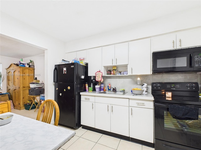 kitchen with black appliances, a sink, white cabinets, and light countertops