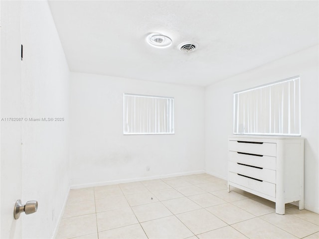 interior space with baseboards, visible vents, and light tile patterned floors
