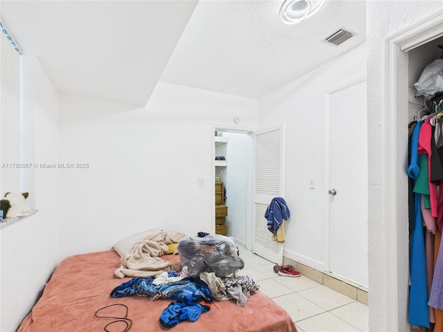 unfurnished bedroom with visible vents and light tile patterned flooring