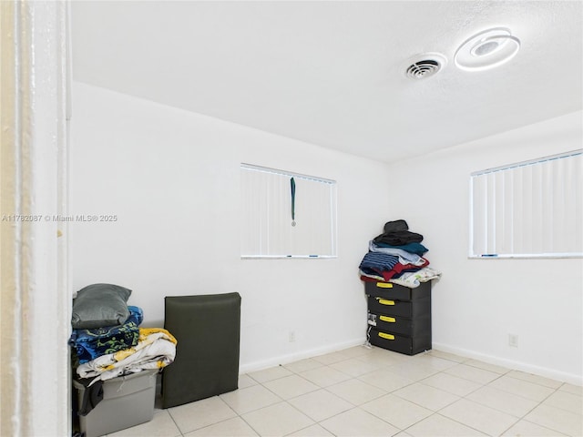 interior space with visible vents, tile patterned floors, and baseboards