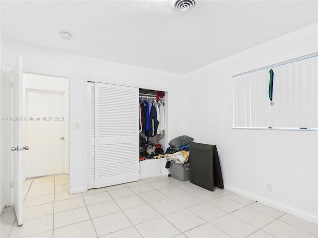 unfurnished bedroom with a closet, visible vents, and baseboards
