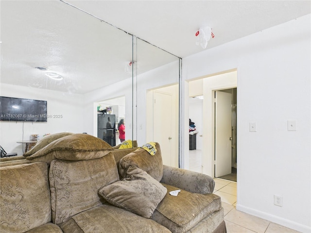 living area featuring baseboards and light tile patterned floors