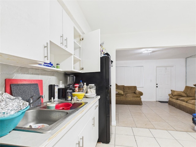 kitchen featuring a sink, light tile patterned flooring, open floor plan, white cabinetry, and open shelves