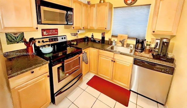 kitchen with light brown cabinetry, appliances with stainless steel finishes, light tile patterned floors, and a sink