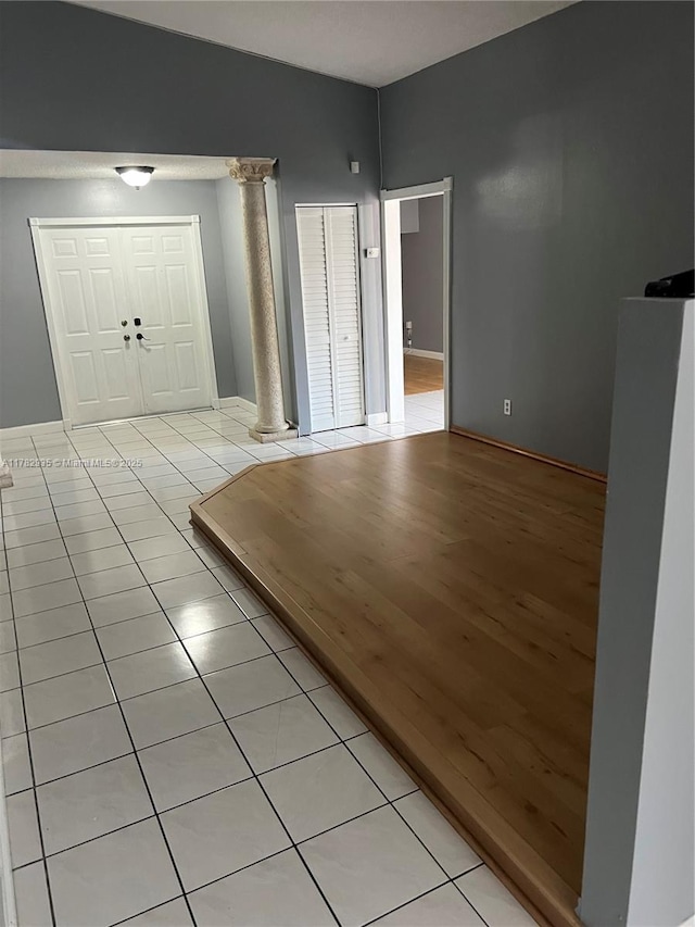 foyer entrance with ornate columns and light tile patterned flooring