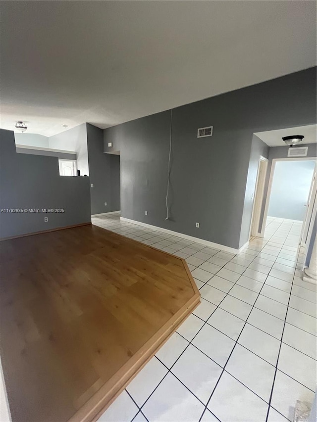 unfurnished room with visible vents, baseboards, and light tile patterned flooring