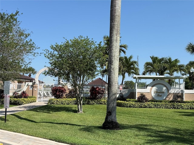 view of property's community with a gate and a lawn