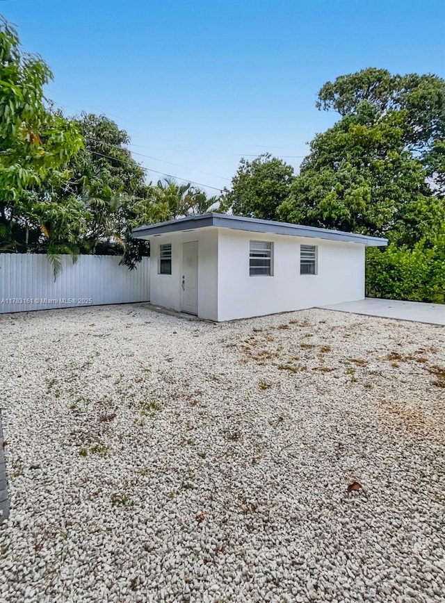 back of property with fence and stucco siding