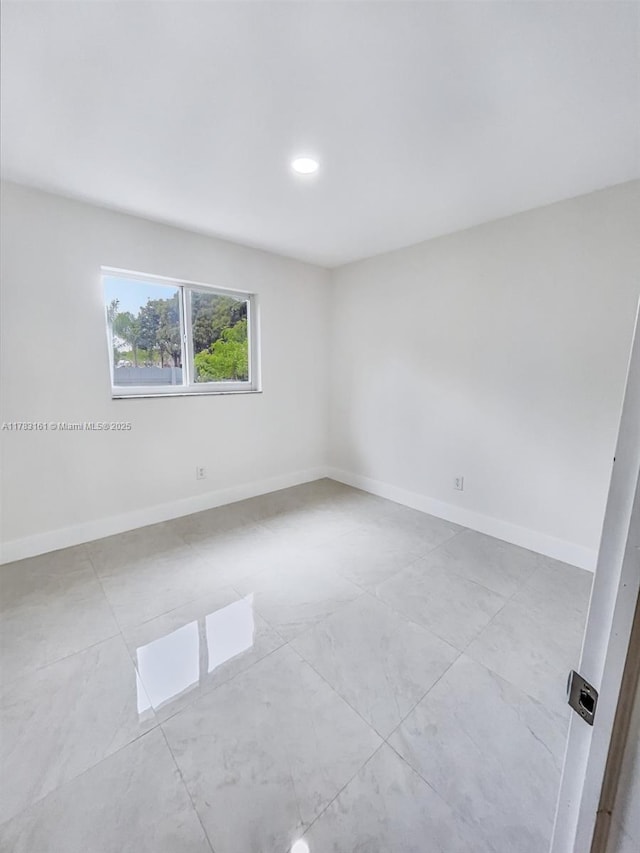 unfurnished room with baseboards