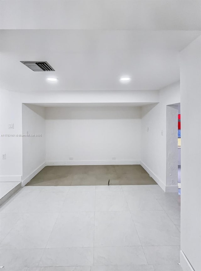 empty room with recessed lighting, baseboards, and light tile patterned floors