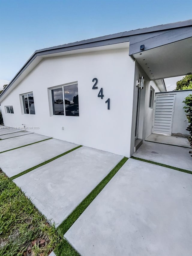 back of property featuring a patio area and stucco siding