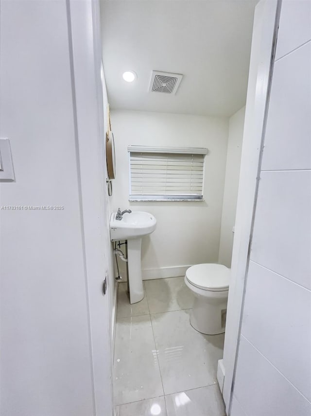 bathroom with toilet, a sink, tile patterned flooring, and recessed lighting