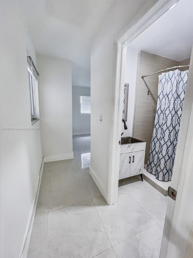 full bath featuring a shower with shower curtain, vanity, tile patterned flooring, and baseboards