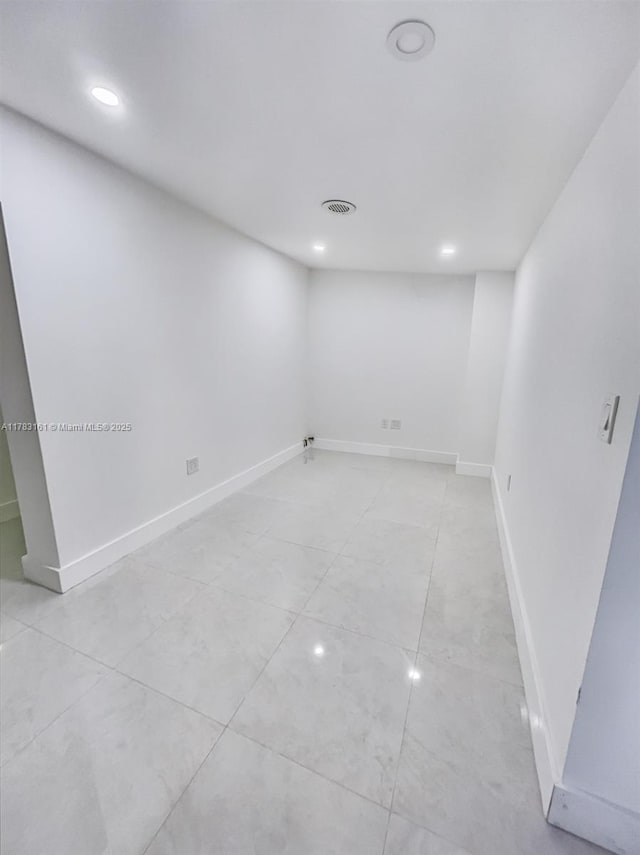 basement featuring recessed lighting, baseboards, and light tile patterned floors