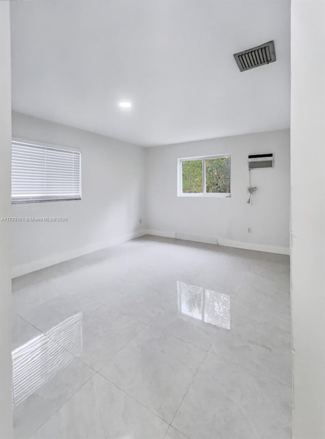 empty room featuring baseboards and recessed lighting