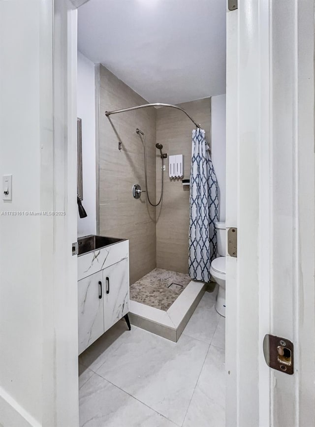 full bathroom featuring a stall shower, toilet, and vanity