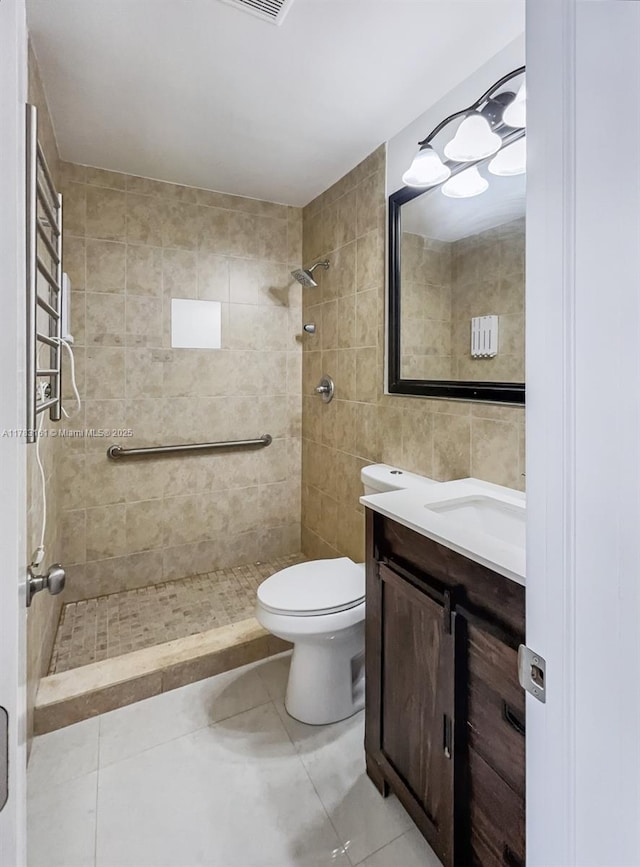 full bath featuring tiled shower, tile patterned floors, tile walls, toilet, and vanity