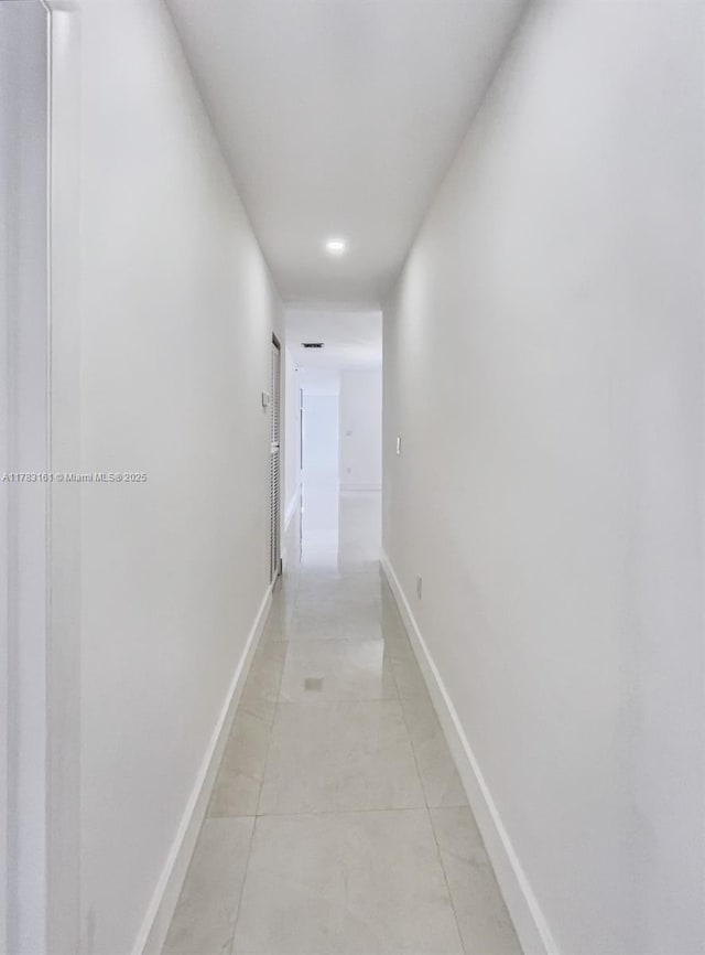 hall with light tile patterned floors and baseboards